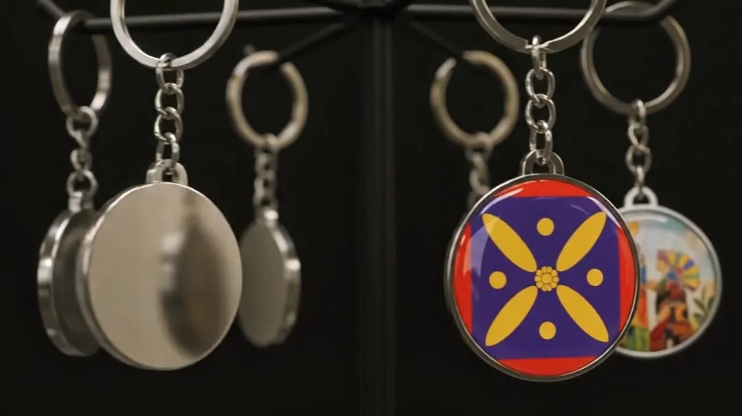 Polished metal disc keyrings on chrome chains, one faced with a gold Persian lotus emblem